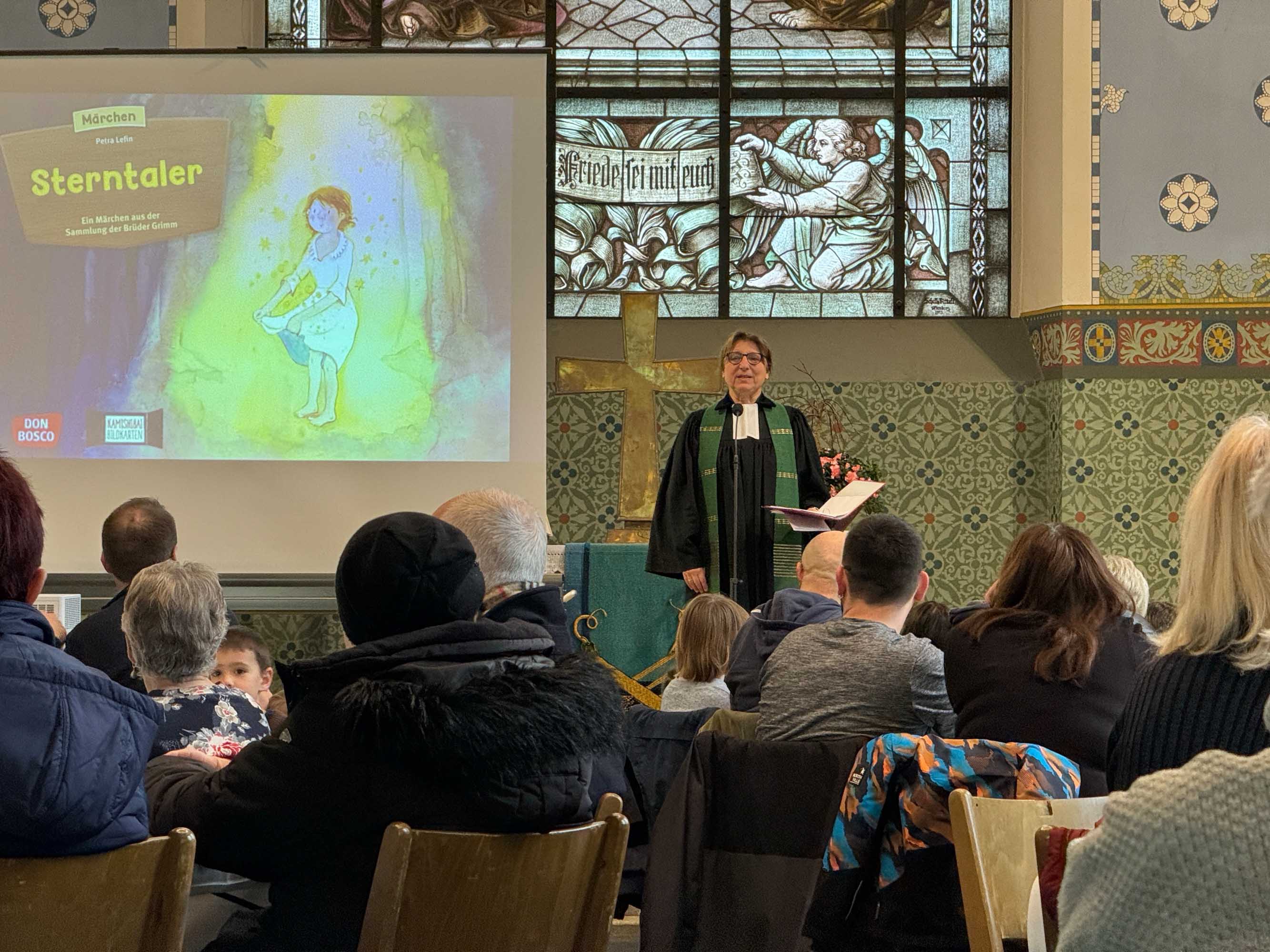 Ein Gottesdienst. Pfarrperson steht auf einer Erhöhung und spricht.
