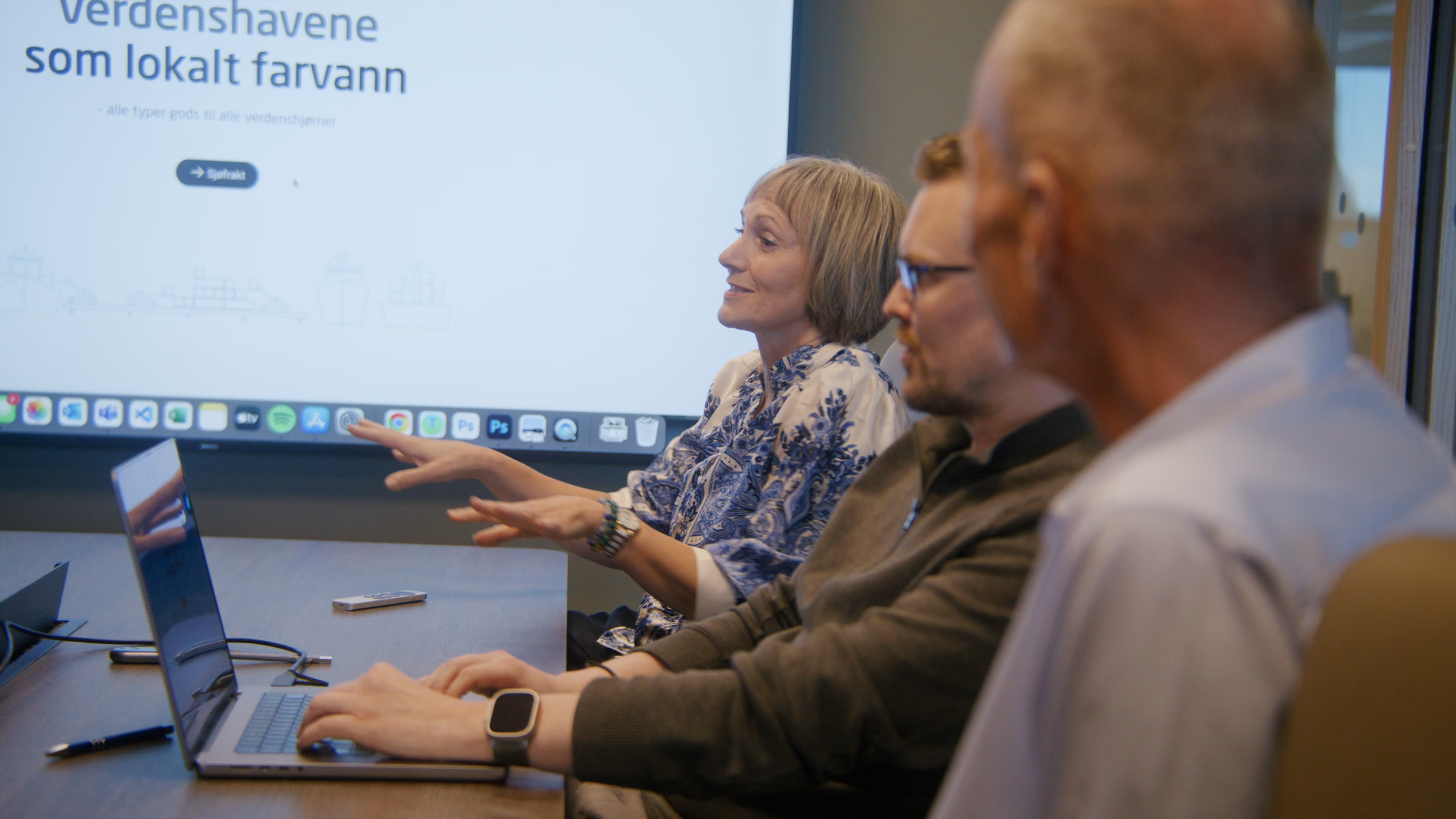 Employees discussing a presentation displayed on screen
