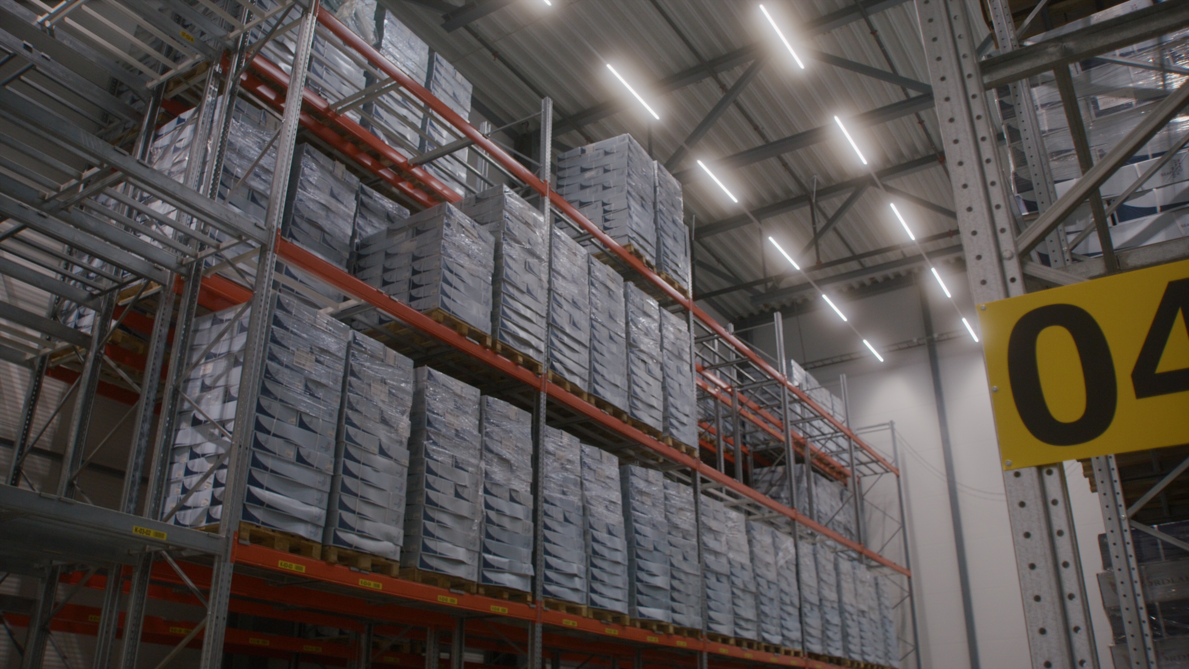 High pallet racks in an illuminated warehouse aisle