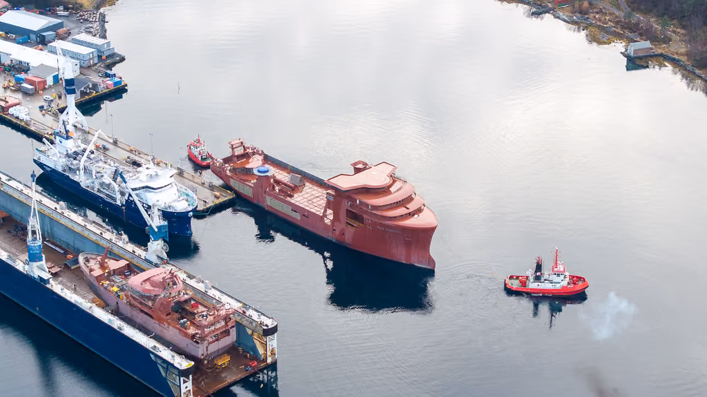 Arbeidsfartøy og taubåt i havnen sett fra luften