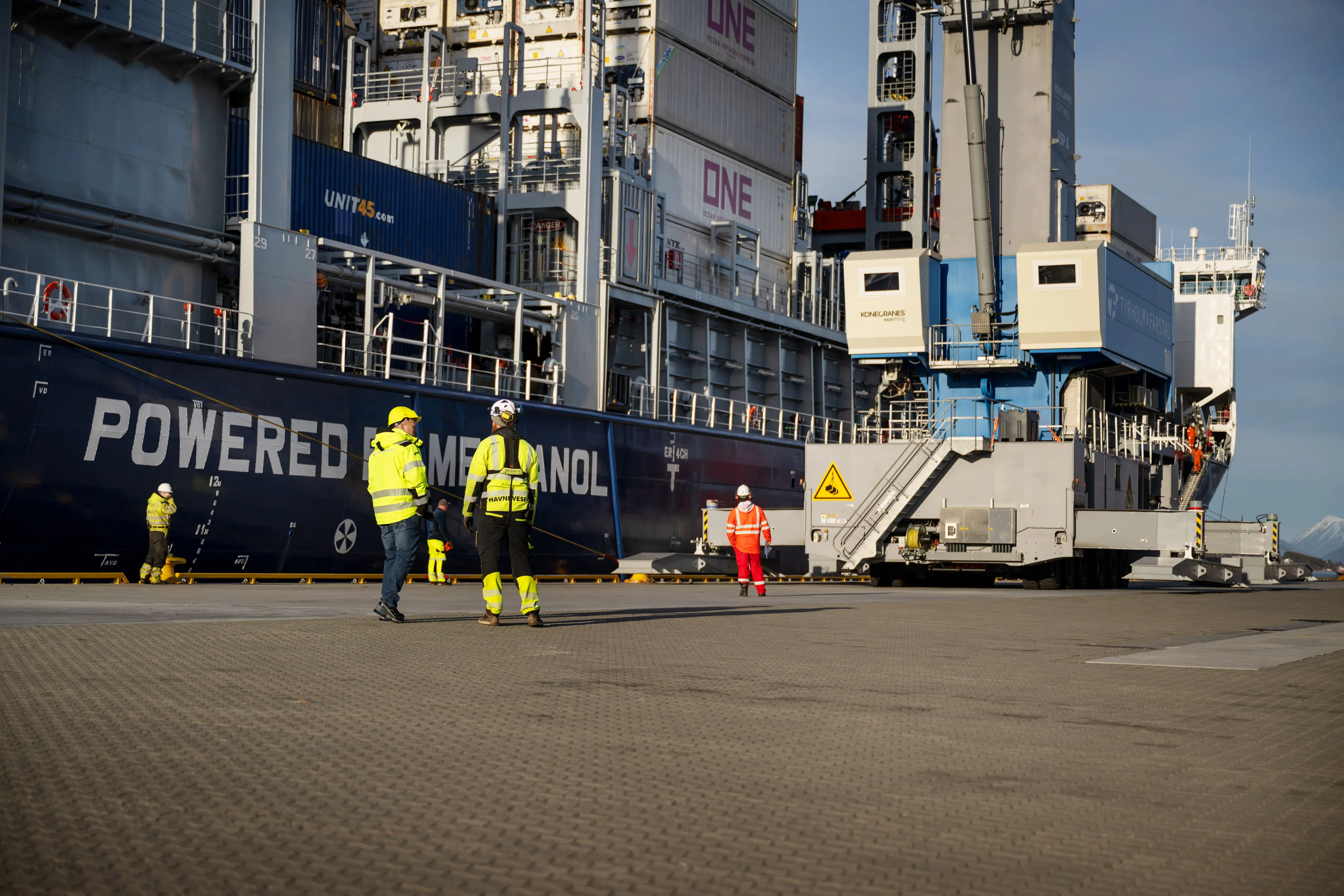 Terminalarbeidere koordinerer lasting ved et containerskip