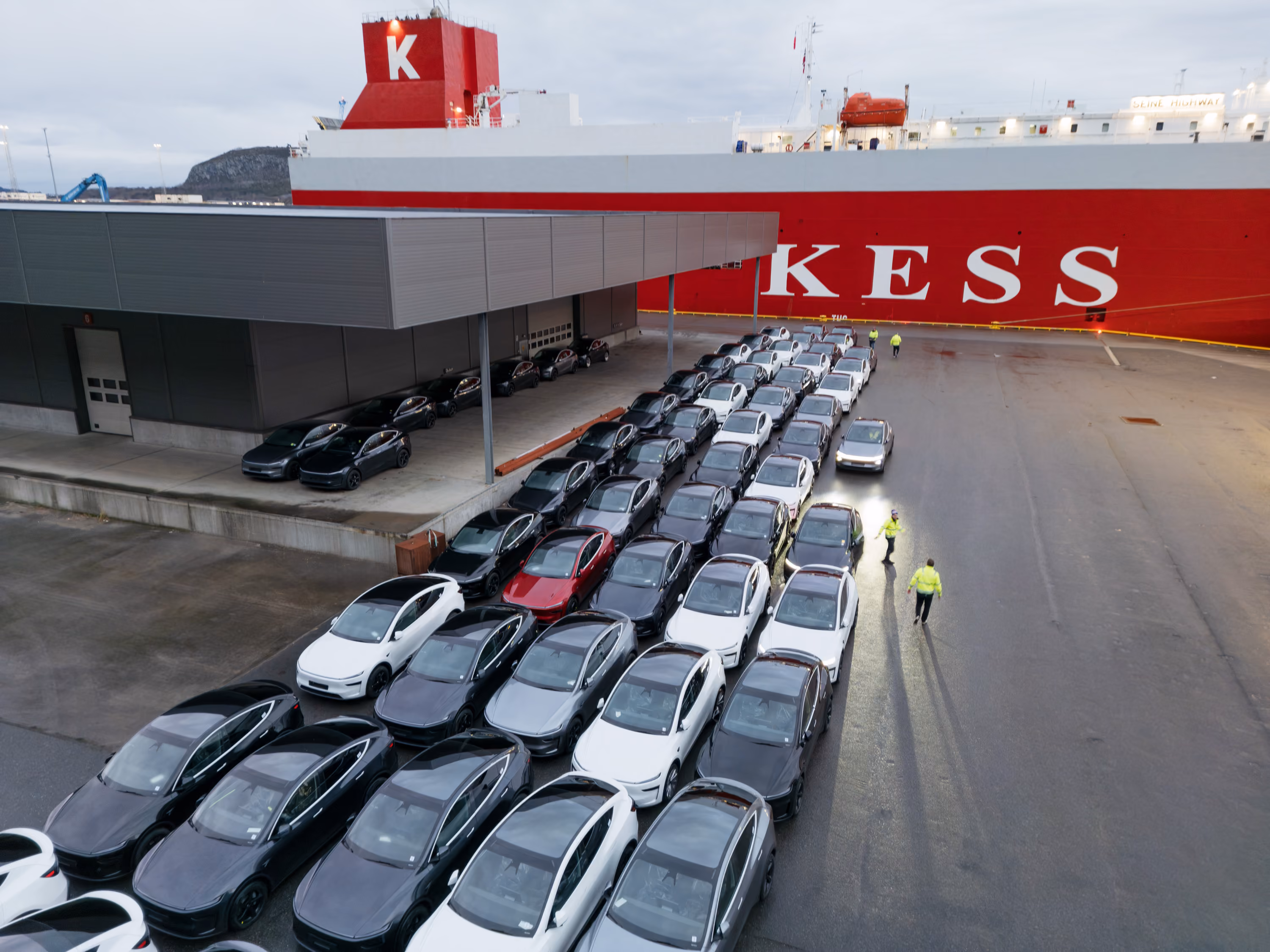 Aerial view of a vehicle terminal with parked cars and a vehicle carrier