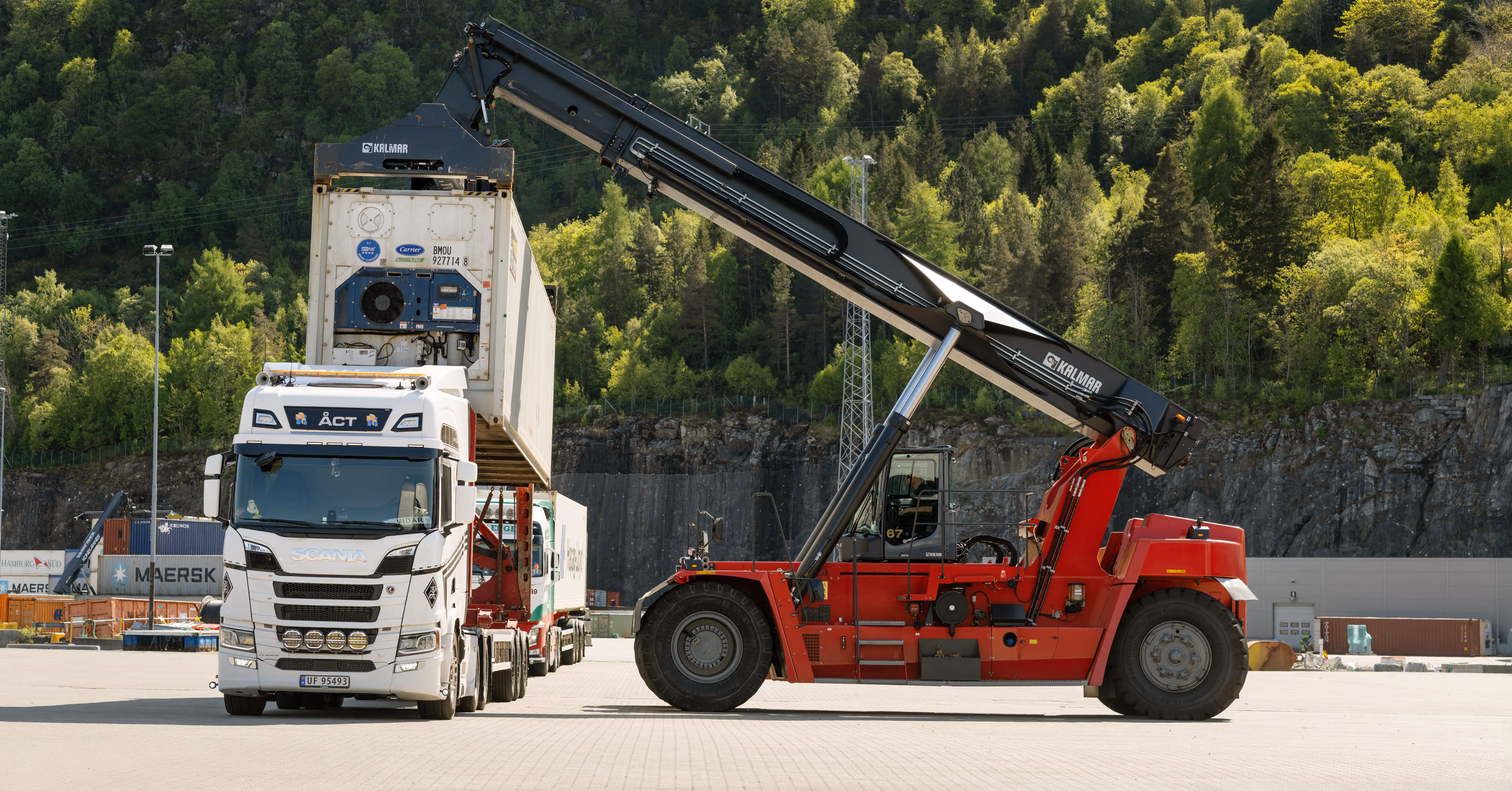 Reachstacker håndterer last ved en lastebil på terminalområdet