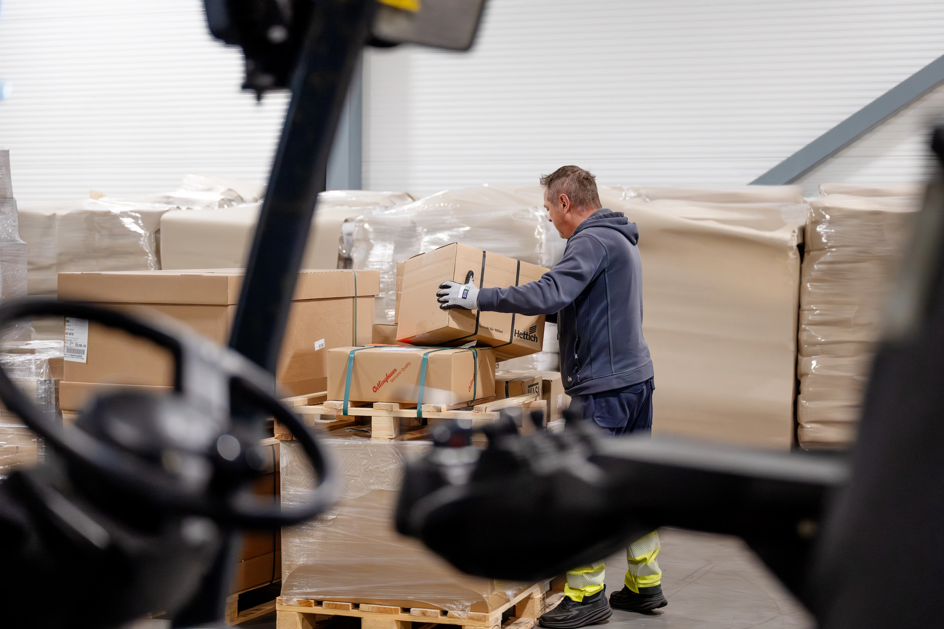 Lagerarbeider håndterer kartonger ved en gaffeltruck