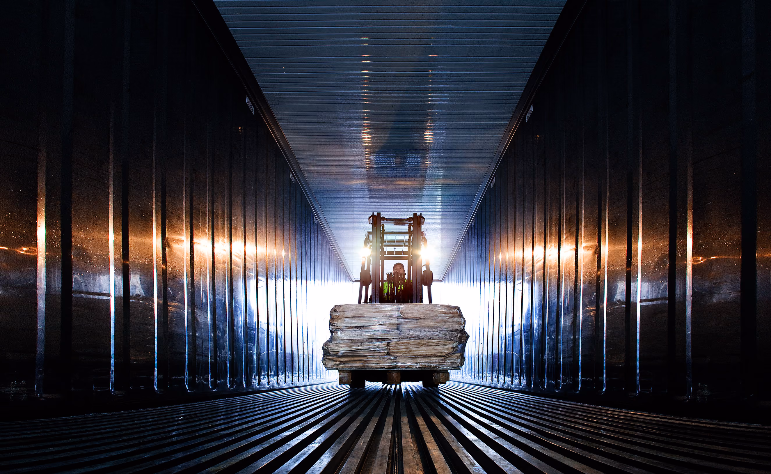 Gaffeltruck transporterer last inne i en container