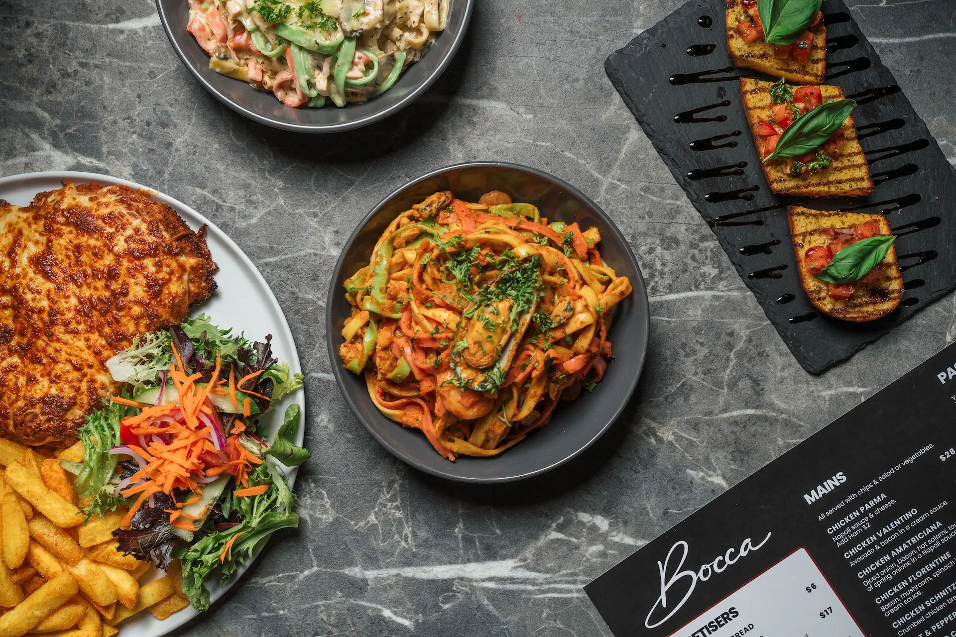 Selection of three freshly made wood-fired pizzas with varied toppings from Bocca Pizza