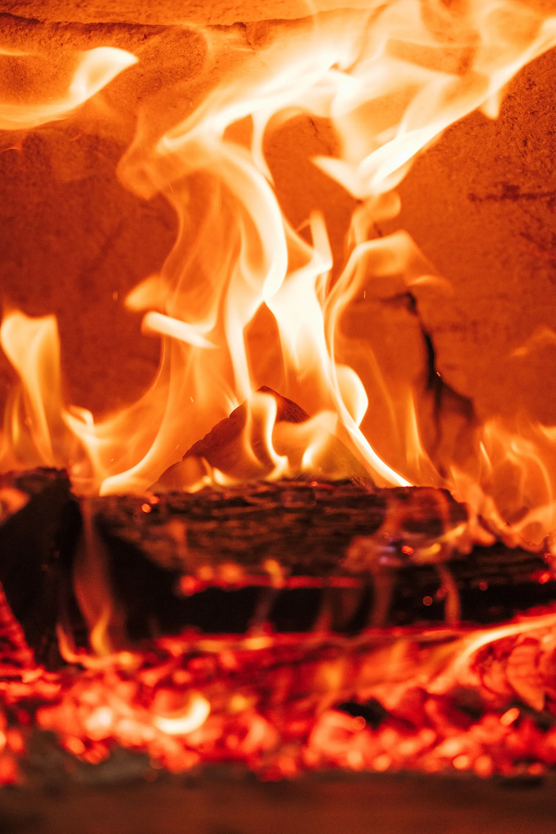 Woodfired pizza oven fire, traditional Italian cooking oven with burning wood flames and glowing heat.