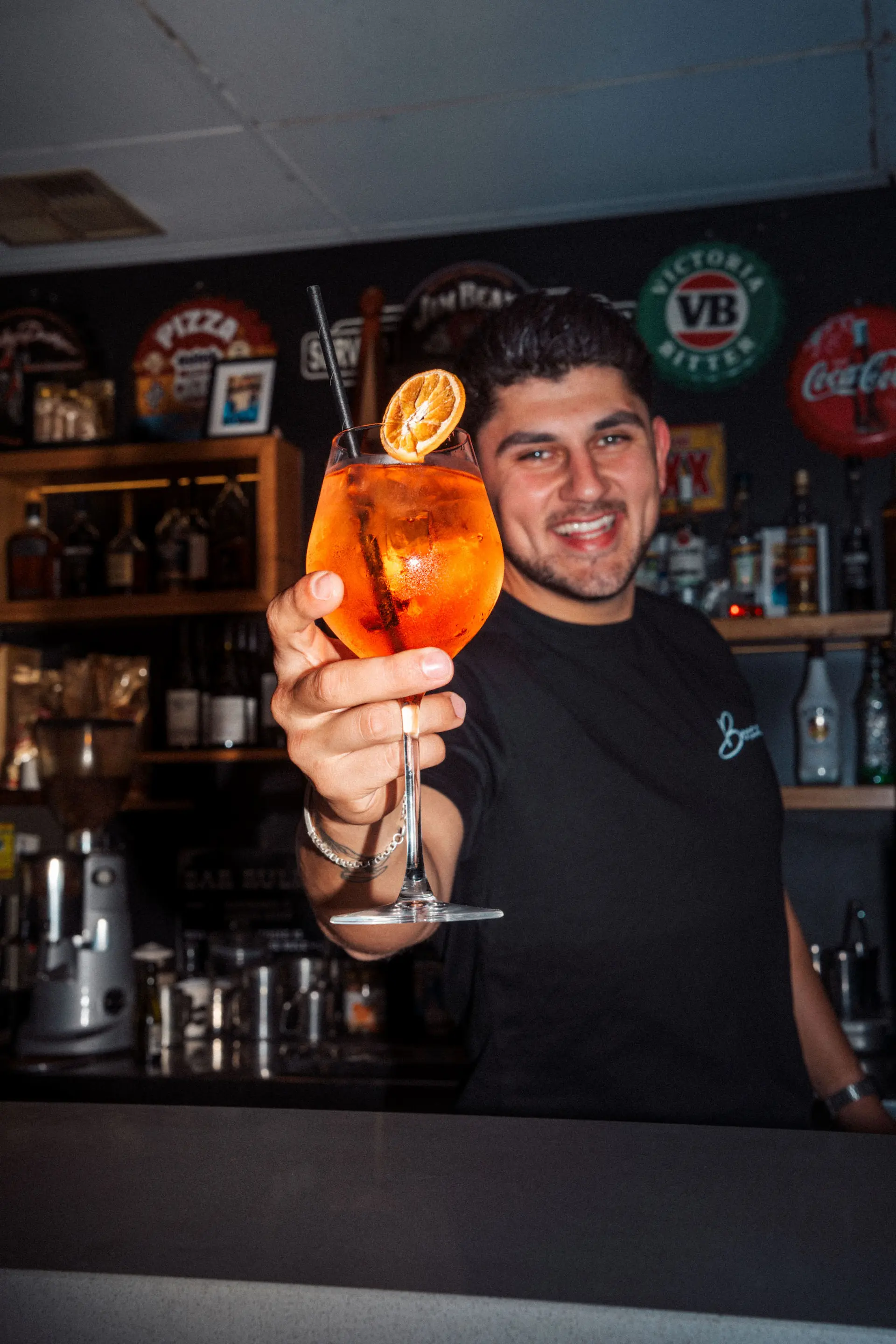 Person celebrating with drink in restaurant, enjoying Italian dining experience.