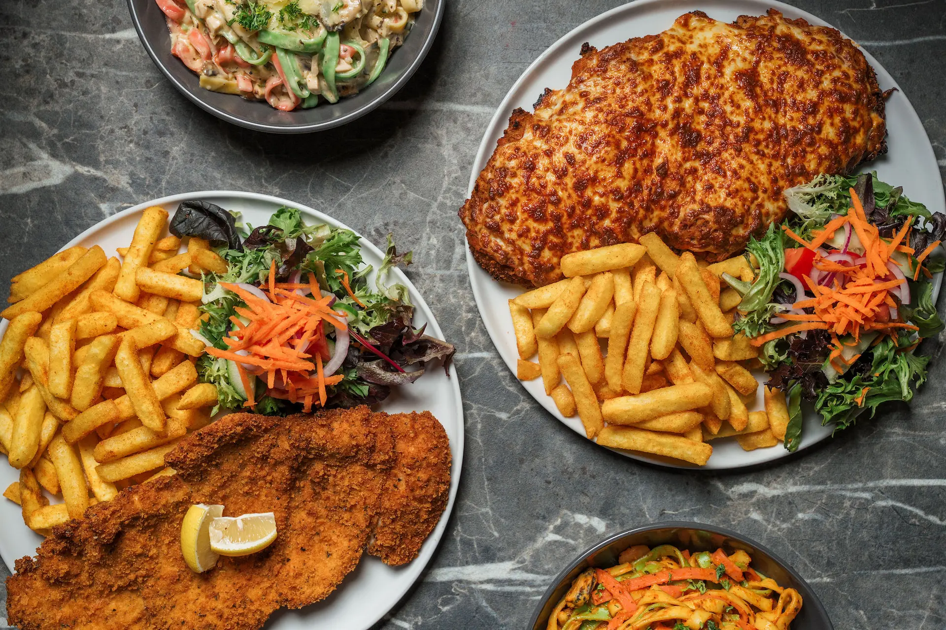 Chicken parma restaurant dish, crispy schnitzel topped with cheese and tomato sauce, served fresh in Melbourne-style dining.