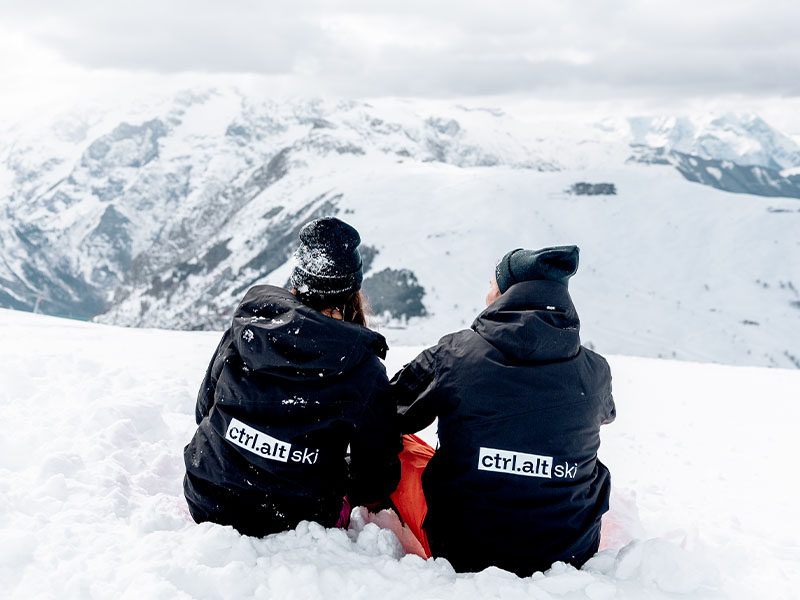 Two ctrl alt connect founders, Jack and Kat, sit together on top of a mountain overlooking the beautiful scenery