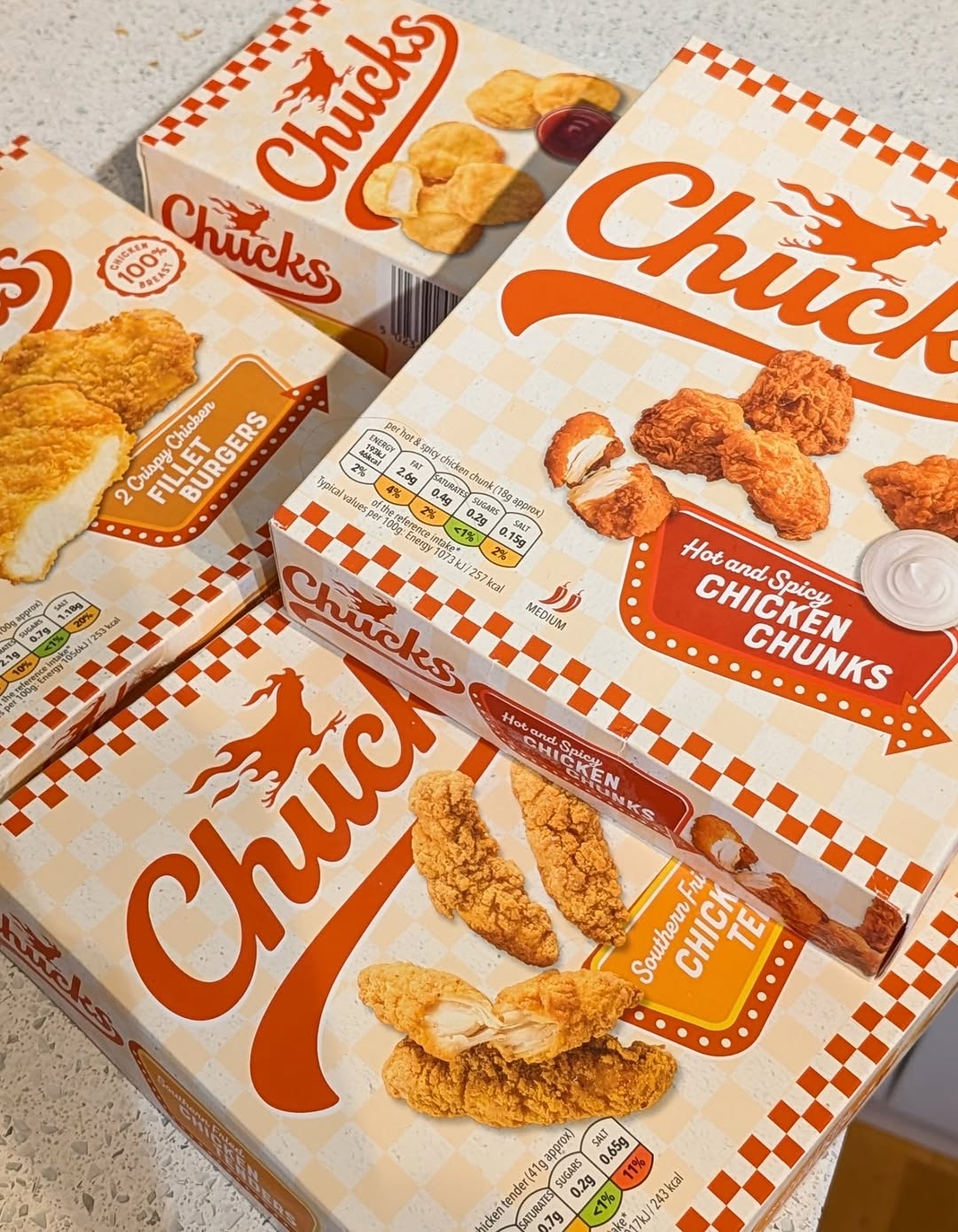 Boxes of Chucks brand fried chicken products, including hot and spicy chicken chunks, southern fried chicken tenders, and crispy chicken fillet burgers.