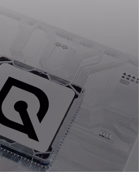 Close-up of a transparent microchip with a black stylized Q logo on the central square component.