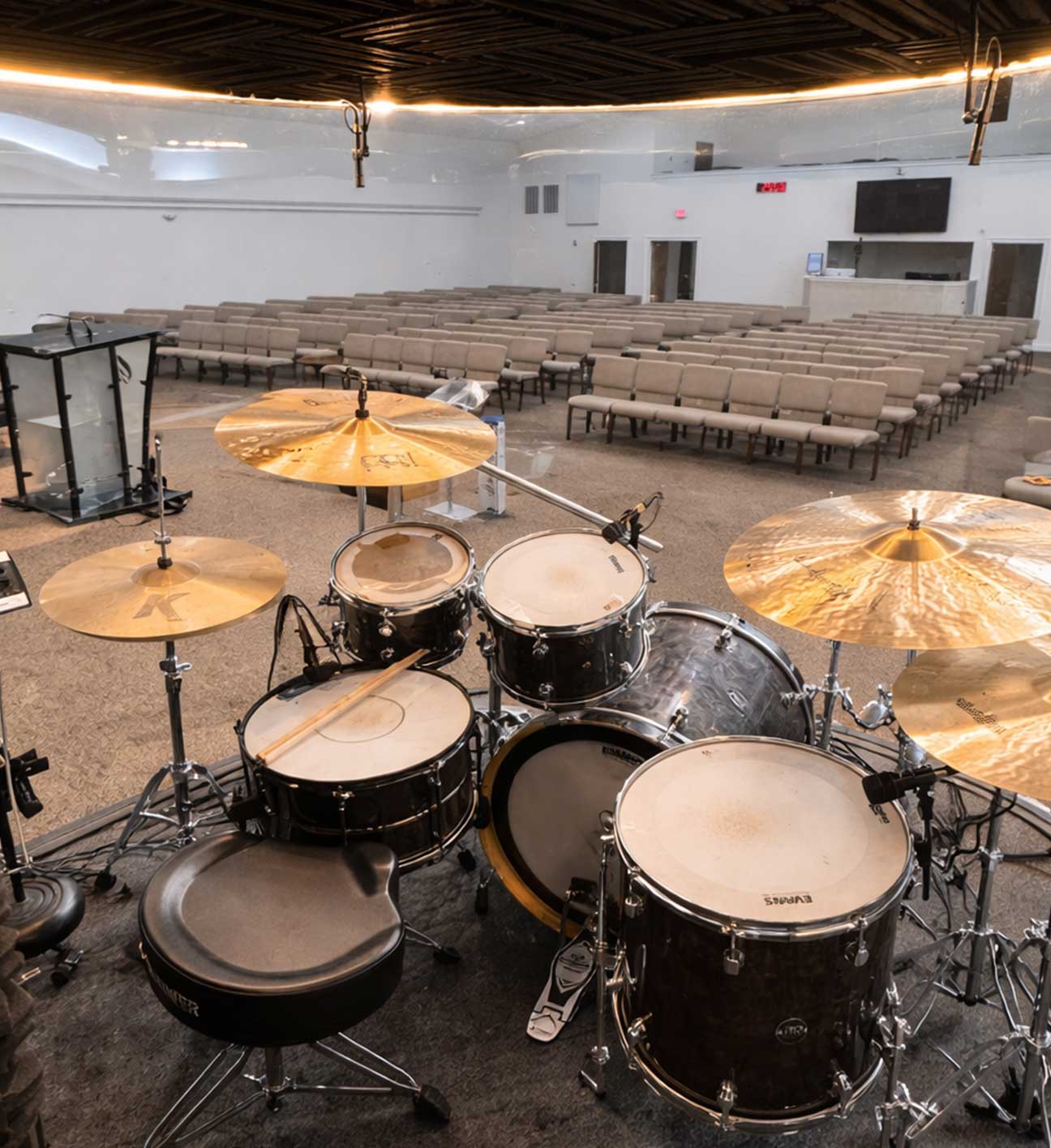 Drummer playing inside an enclosure during a live service