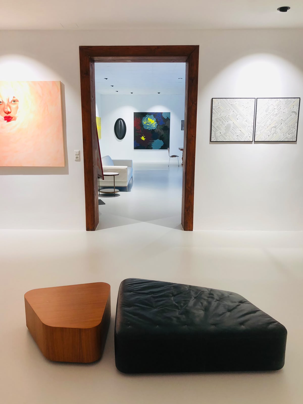 Innenraum der Park Galerie mit modernen Möbeln, Holzrahmen und abstrakter Kunst an den Wänden.