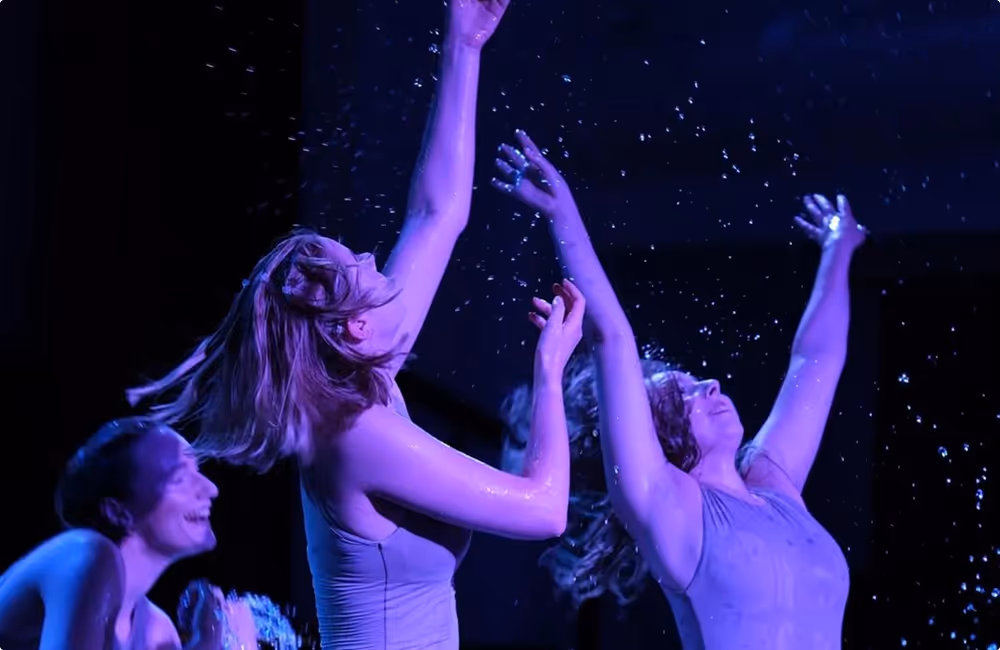Tänzerinnen der Compagnie SI auf der Bühne, die Wasser in die Luft spritzen