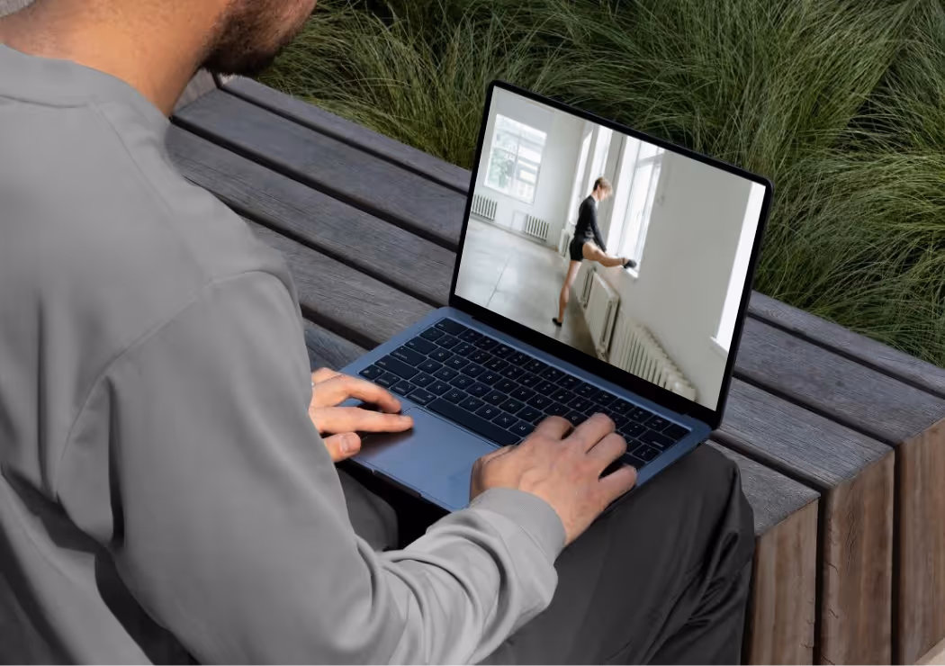 Ein Mann, der auf einen Computer schaut, auf dessen Bildschirm ein Tänzer zu sehen ist