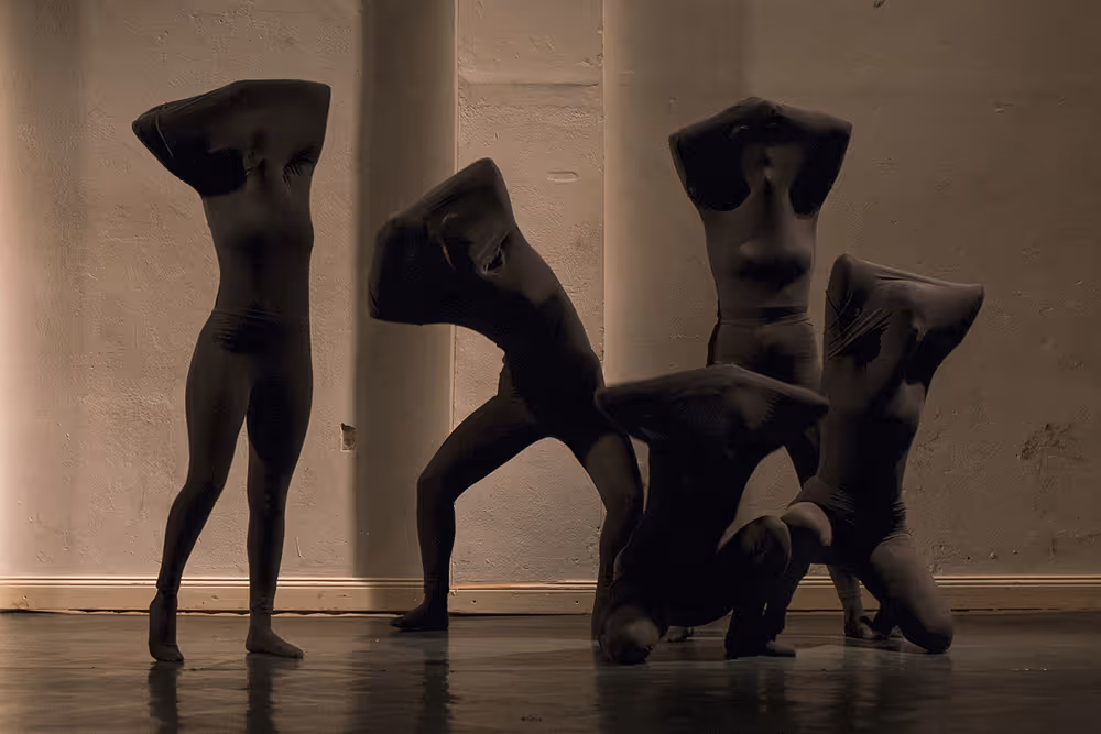 Tänzer auf der Bühne, die ihre Hemden über den Kopf gezogen haben