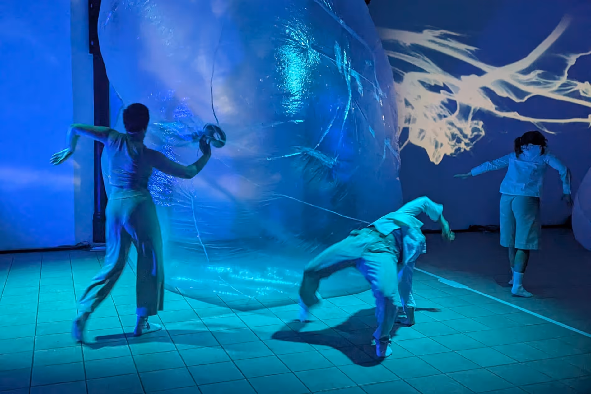 Tänzer auf der Bühne mit Projektionen und einer riesigen Plastikblase