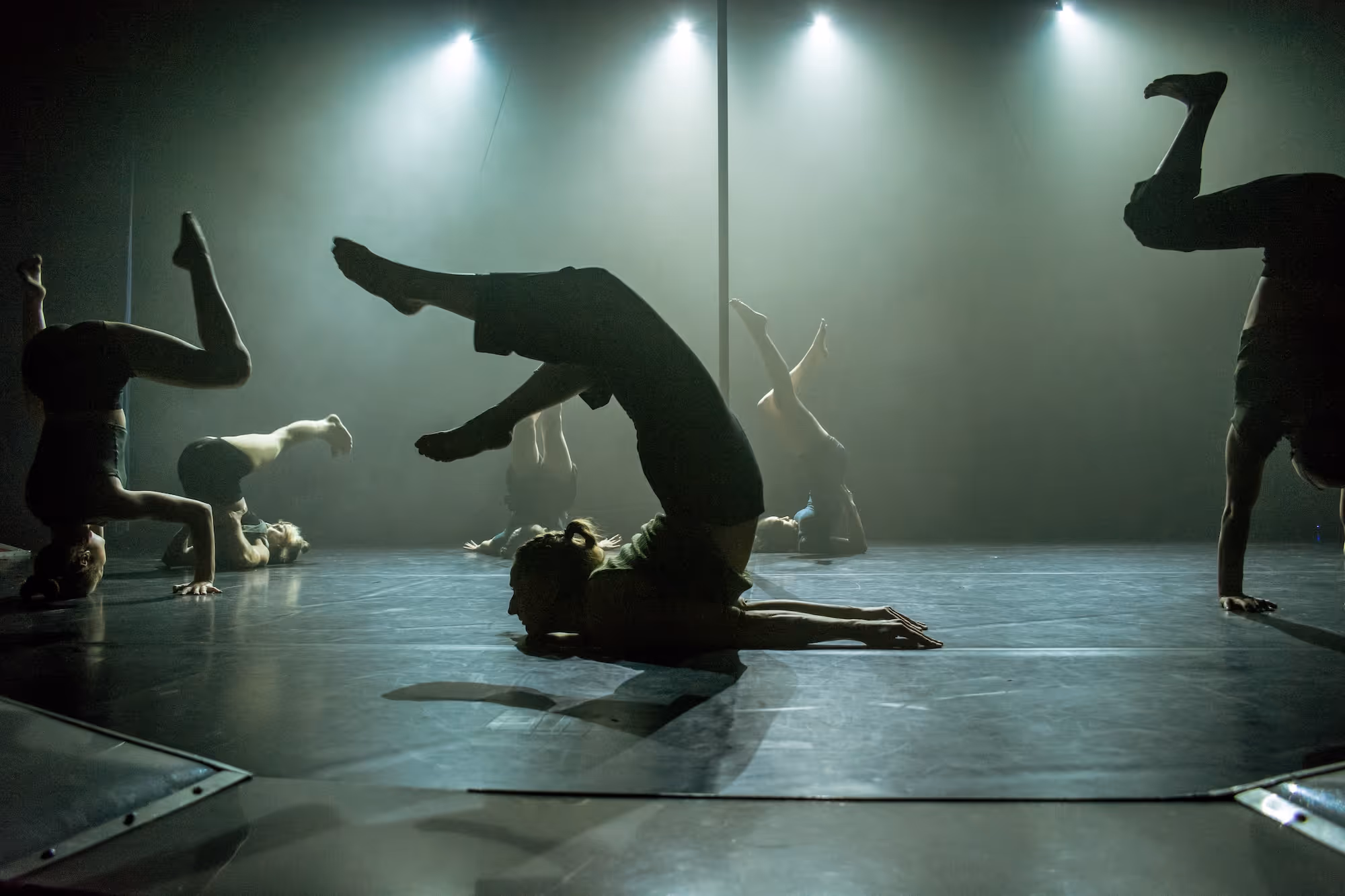 Künstler:innen auf der Bühne, die auf dem Kopf balancieren