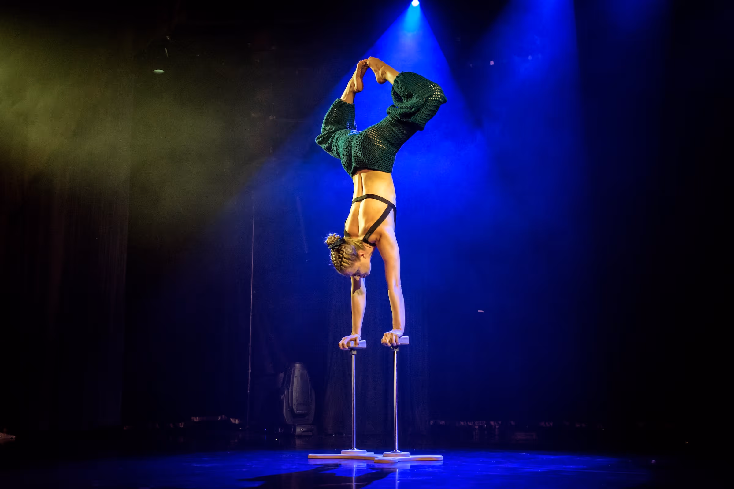 Zirkusartist, der auf Stelzen einen Handstand macht