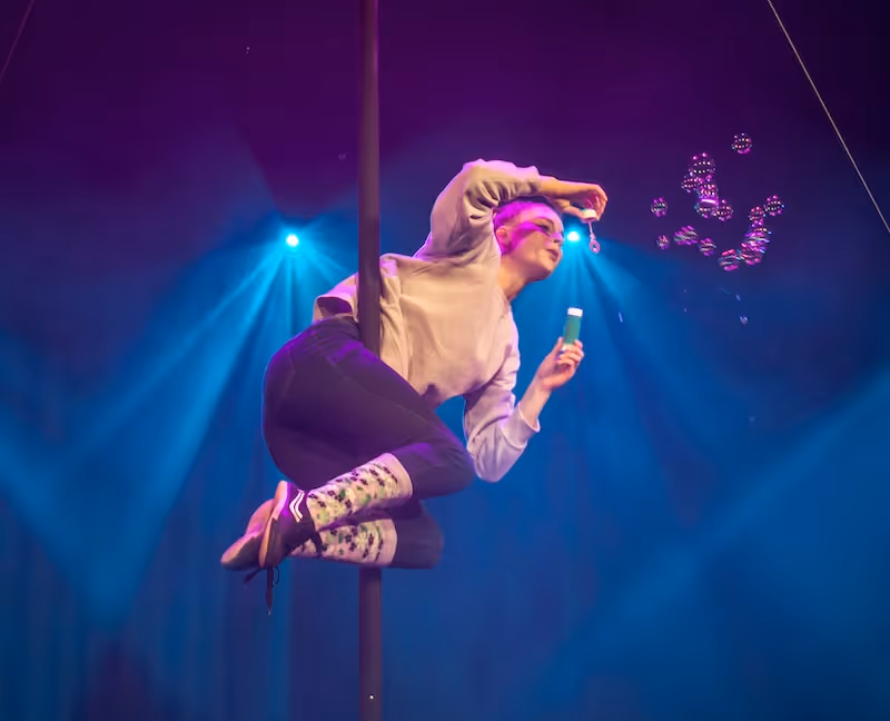 Zirkusartist, der auf der Bühne Seifenblasen pustet