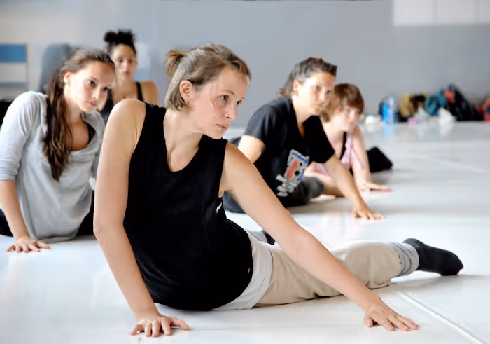 Eine Tanzlehrerin, die Tänzern Bodenarbeit beibringt