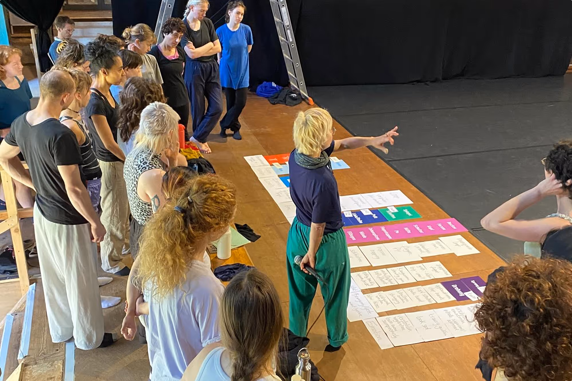 Eine Tanzlehrerin erklärt den Teilnehmern im Tanzstudio die Übung