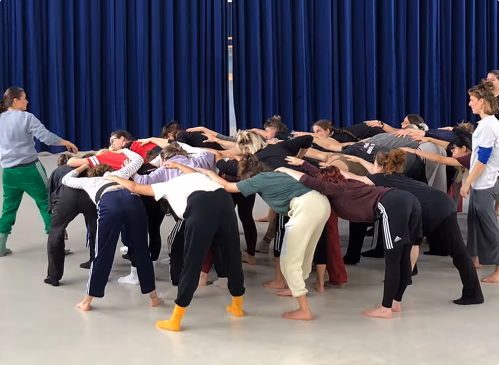 Tanzworkshop, bei dem die Teilnehmer ihre Hände auf den Rücken der anderen legen