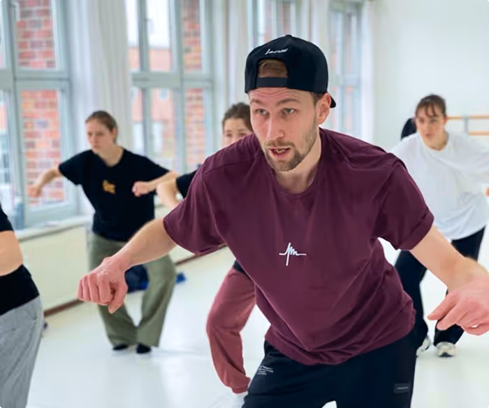 ein Tanzlehrer, der in Tanzkursen die Bewegungen vorführt