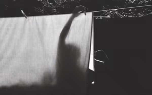 eine Person, die Wäsche auf einer Wäscheleine aufhängt