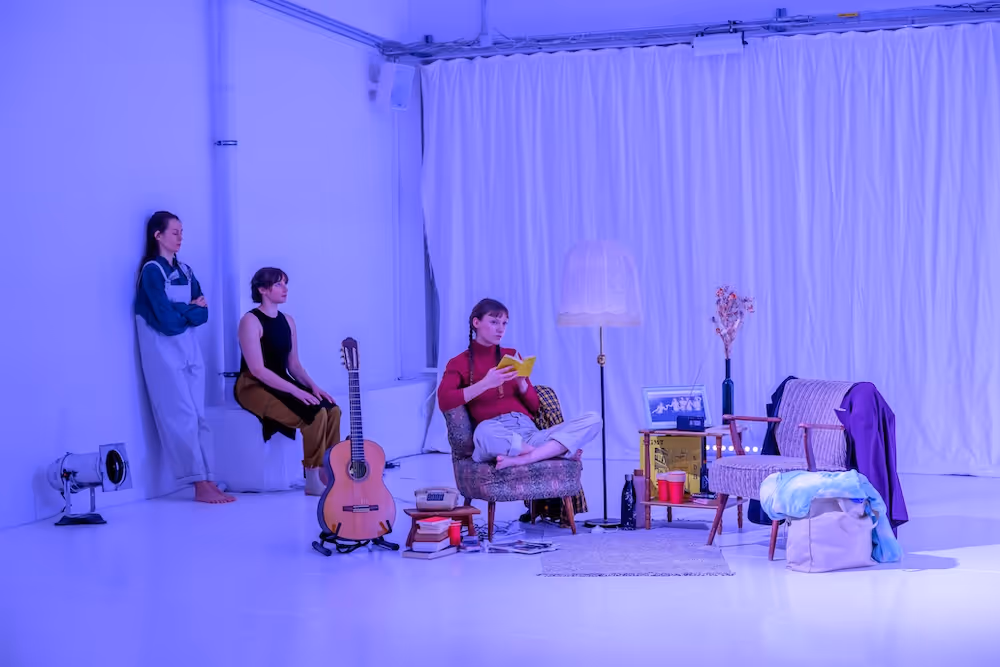 3 Tänzerinnen auf der Bühne mit Stühlen, einem Tisch und einer Lampe