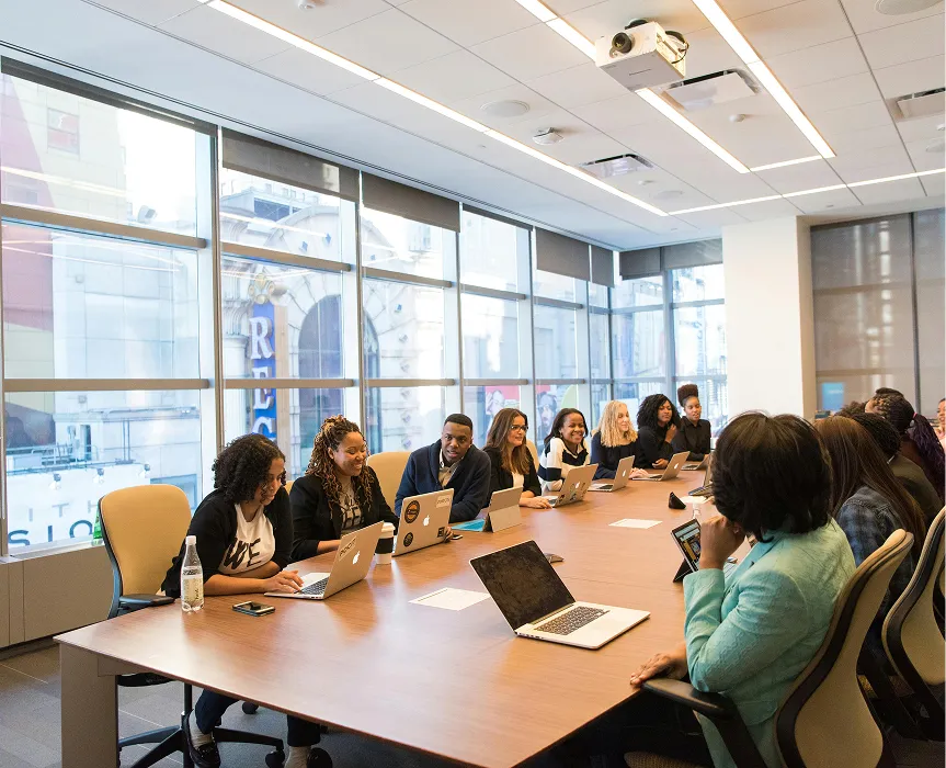 Colleagues in a meeting around a long boardroom table