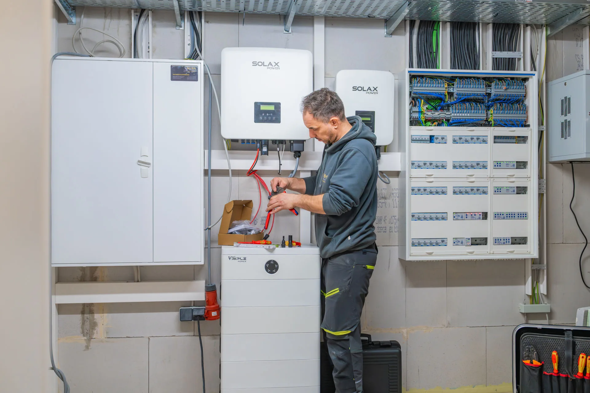 Ein Elektroniker von Reba Solar bereitet einen Speicher für den Anschluss an einen Schaltschrank vor 