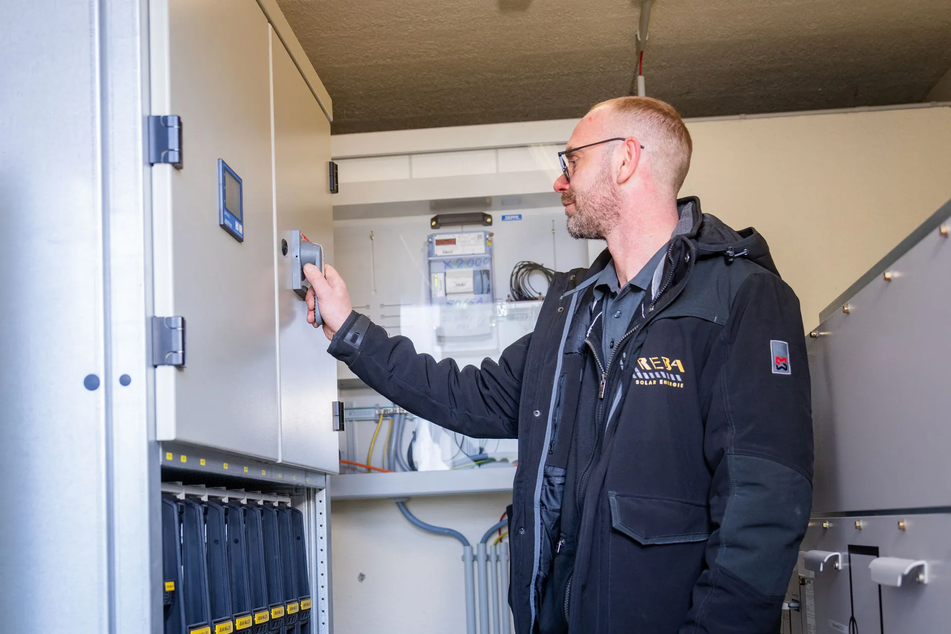 Reba Solar Mitarbeiter überprüft Transformatoren bei einem Kunden an einer installierten Anlage.