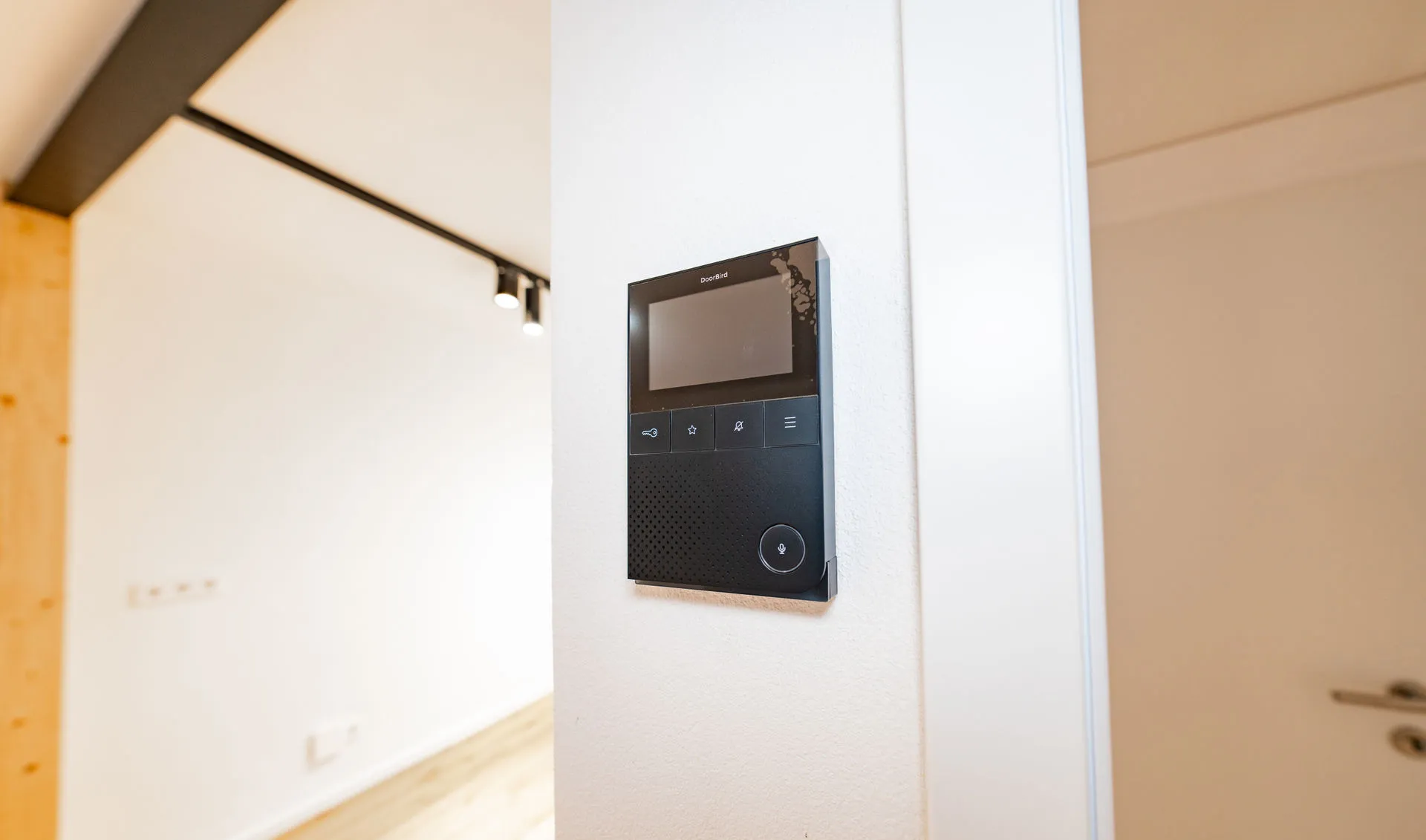 Smarte DoorBird IP-Video-Innenstation zur Türkommunikation, installiert in einem modernen Interieur.