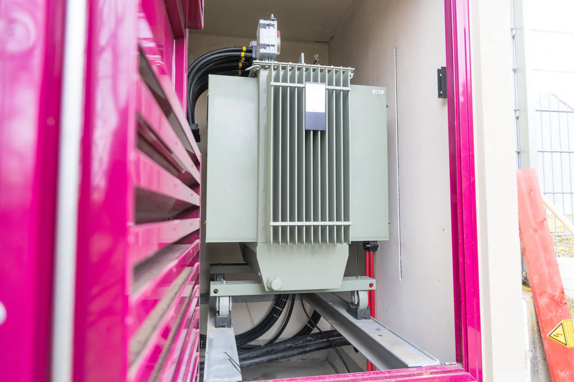 Professionell installierter Transformator in einer Kompaktstation mit fachgerechter Hochspannungsverkabelung.