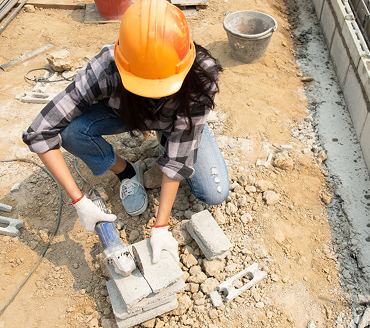 A builder cutting concrete