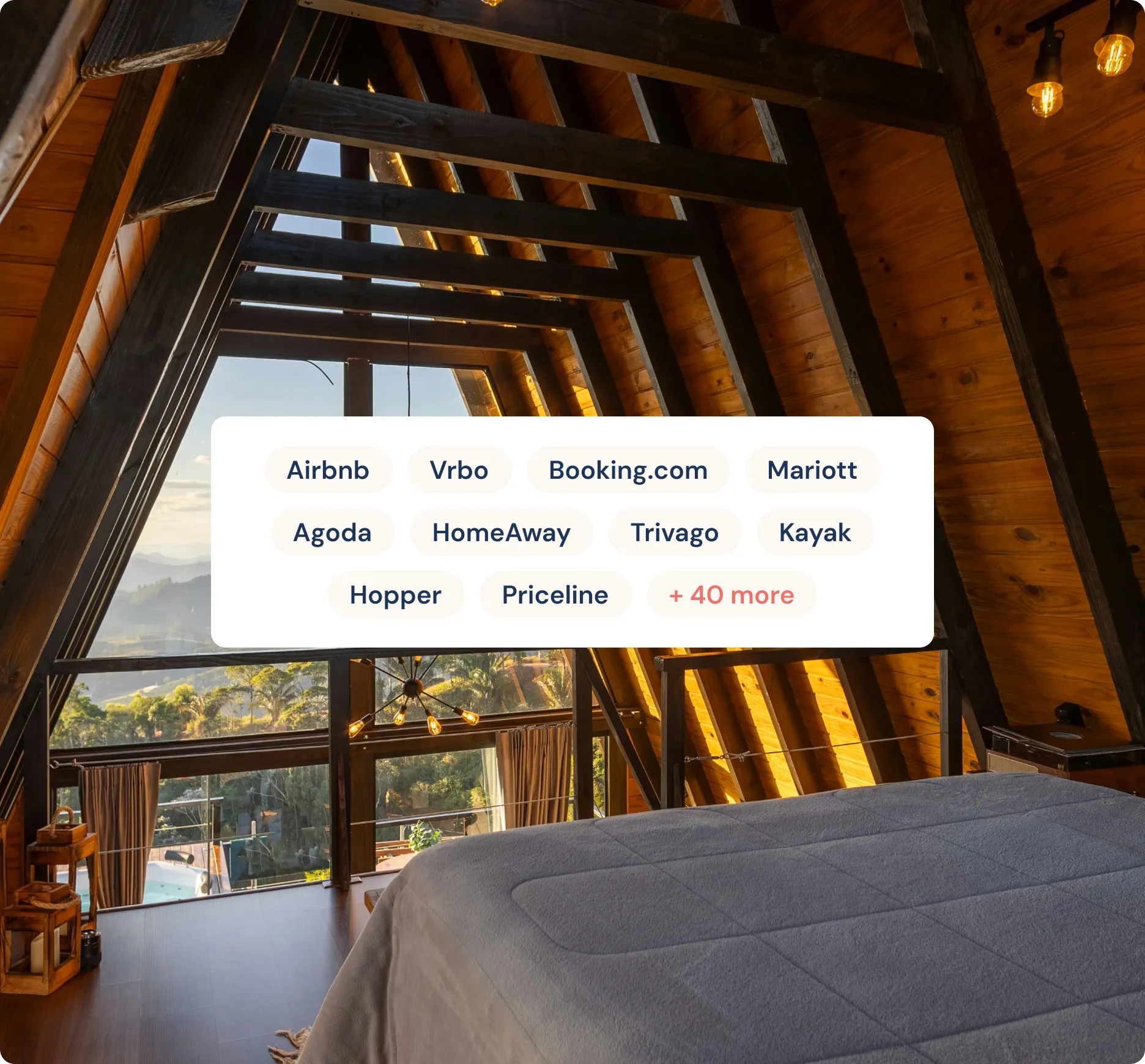 Cozy A-frame wooden cabin bedroom with a large window overlooking a scenic view of trees and mountains at sunset.