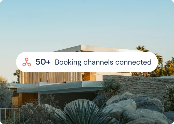Modern house surrounded by desert plants and rocks under a clear blue sky with overlay text stating '50+ Booking channels connected'.