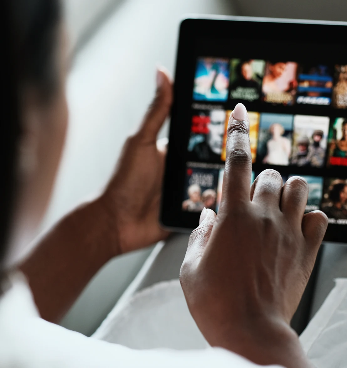 Person browsing a streaming entertainment catalog on a tablet