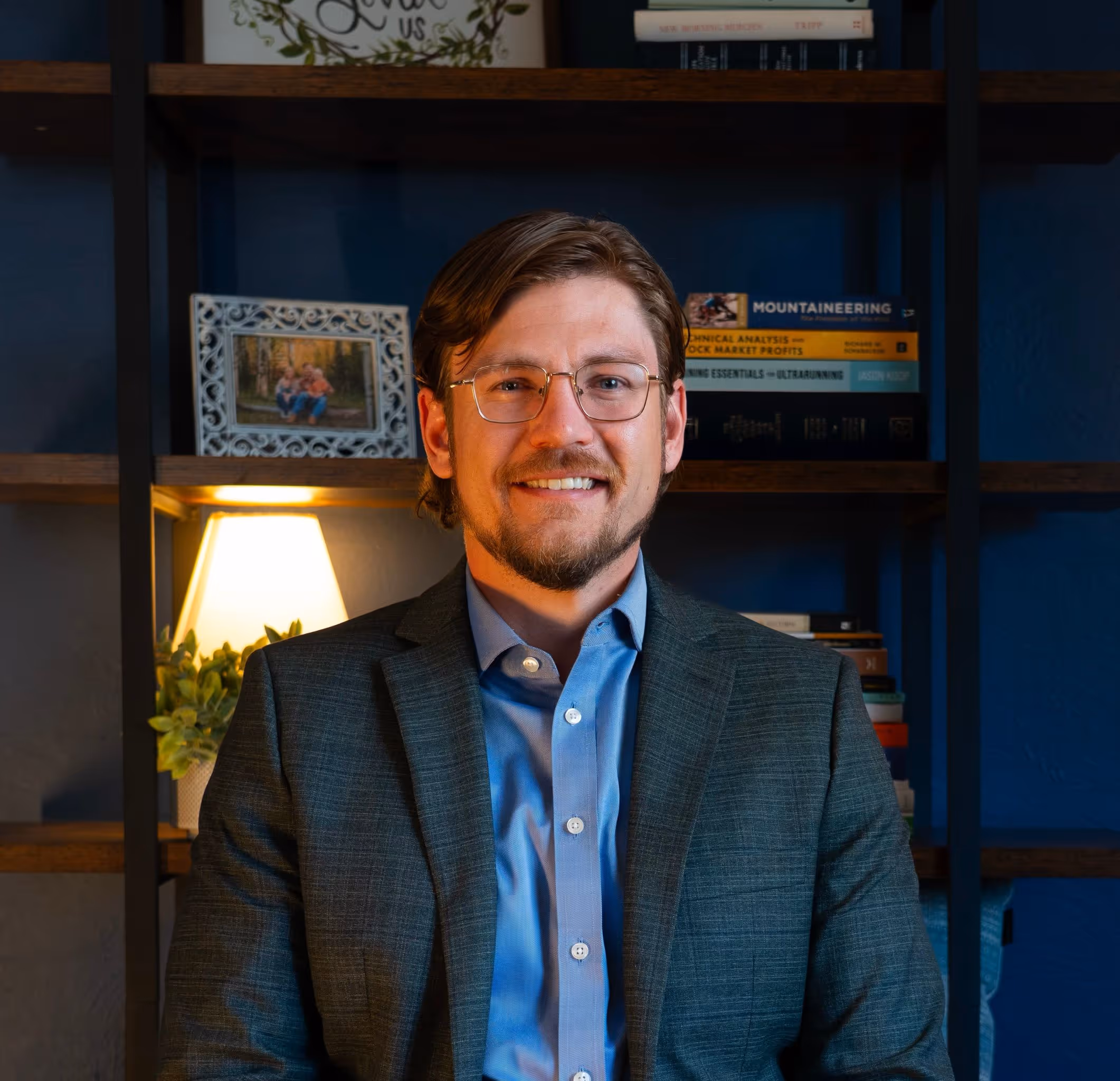Smiling older couple shaking hands with a businessman across a table in an office.
