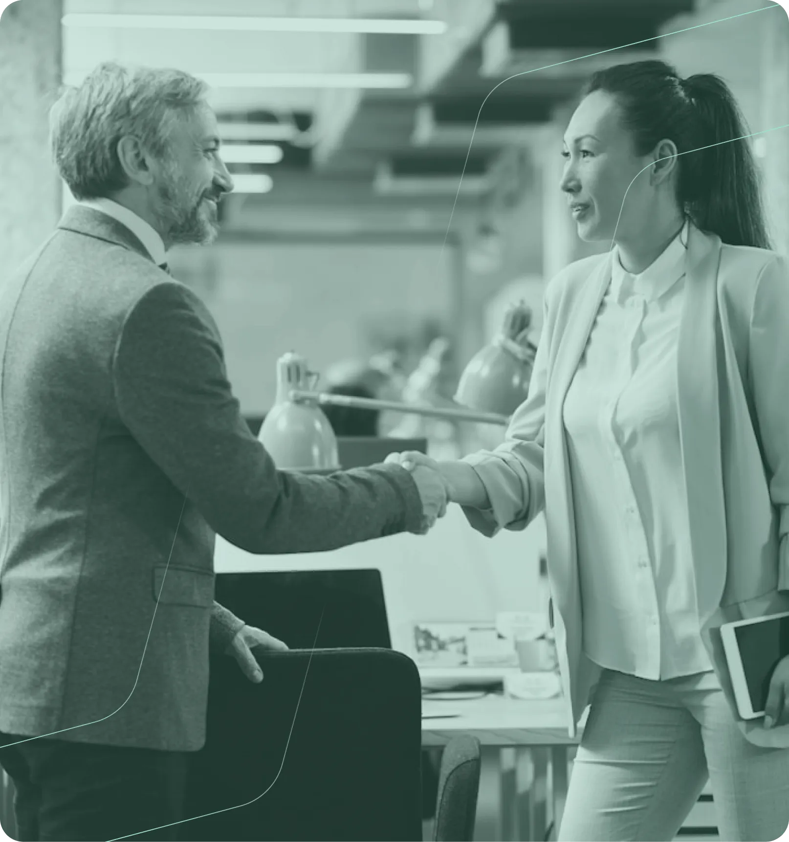 Deux professionnels, un homme plus âgé et une femme plus jeune, se serrent la main dans un bureau moderne, la femme tenant une tablette.