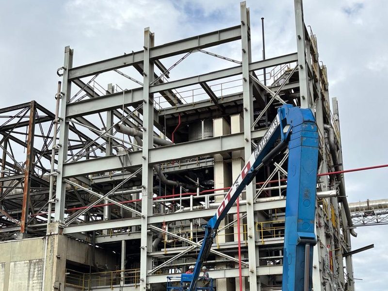 Estrutura metálica da planta durante a desmobilização, com plataforma elevatória e guindaste.