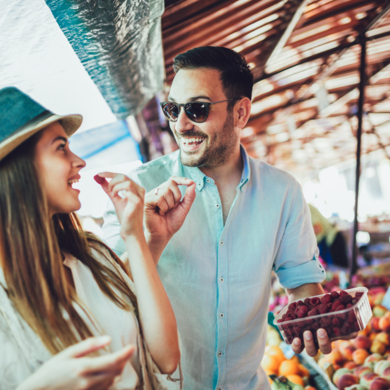Man and woman eating fruit at outdoor market stock image