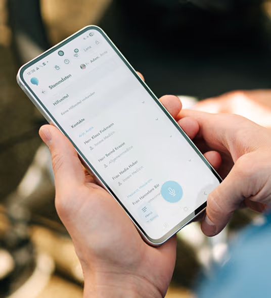 Person hält ein Smartphone mit einer geöffneten Kontaktliste in deutscher Sprache.