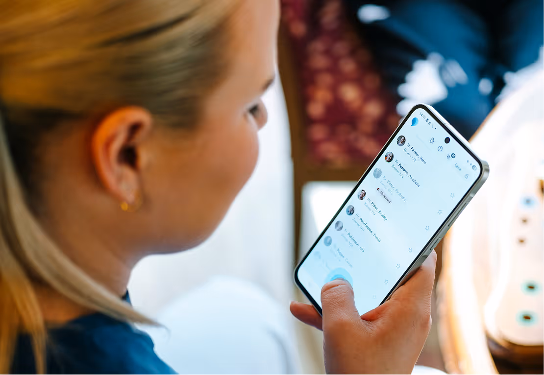 Frau blickt auf ein Smartphone mit einer geöffneten Chat-App.