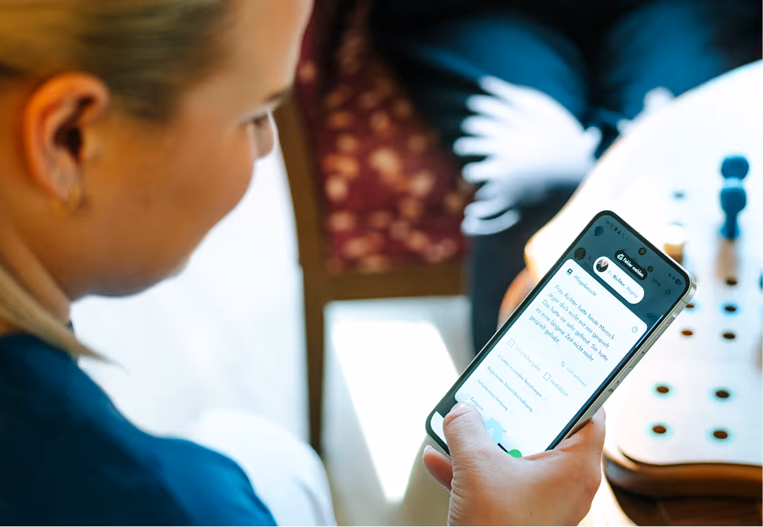Person, die ein Smartphone in der Hand hält und eine Nachricht oder App mit Text liest.