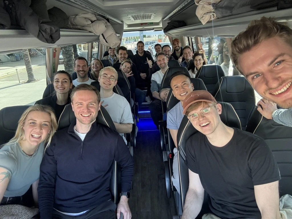 Eine Gruppe lächelnder voize-Mitarbeiter bei einem Teamevent in einem Shuttlebus, die die positive Unternehmenskultur zeigt.