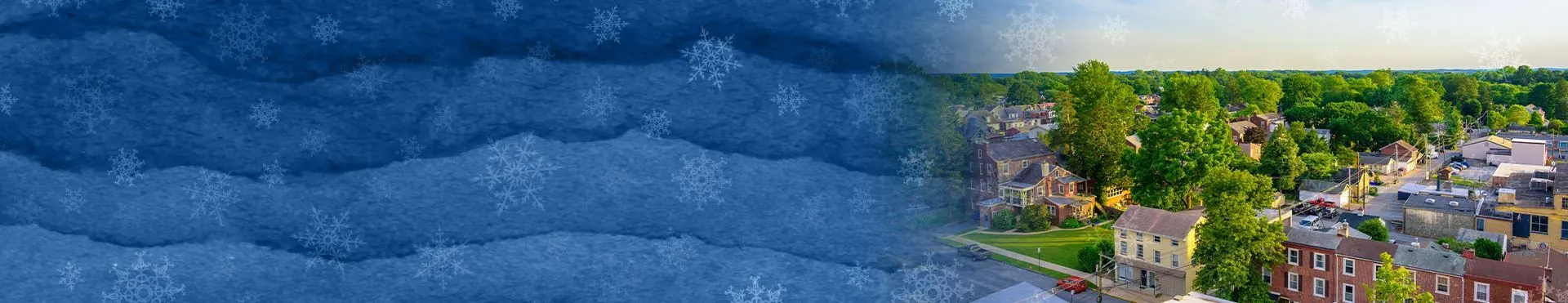 Aerial view of a residential neighborhood with trees and houses under a sky with snowflake patterns overlay.