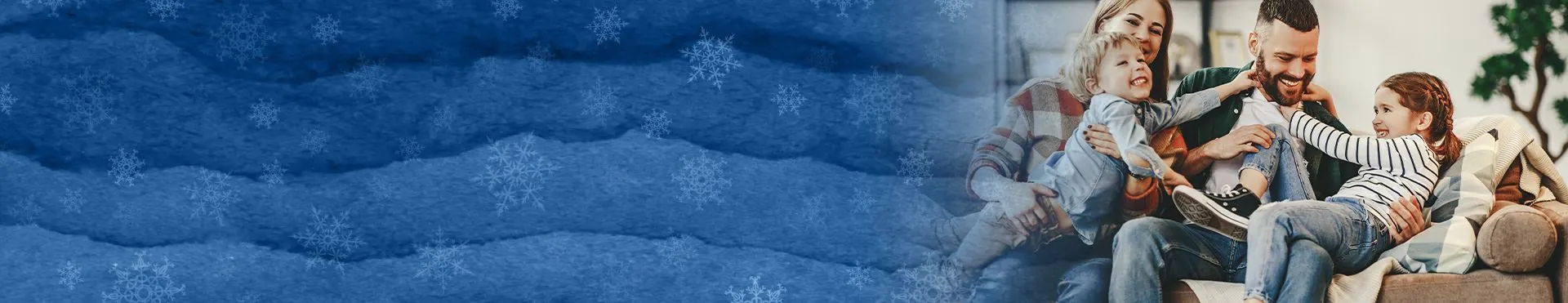 Happy family with two children playing and laughing on a couch with blue snowflake background.